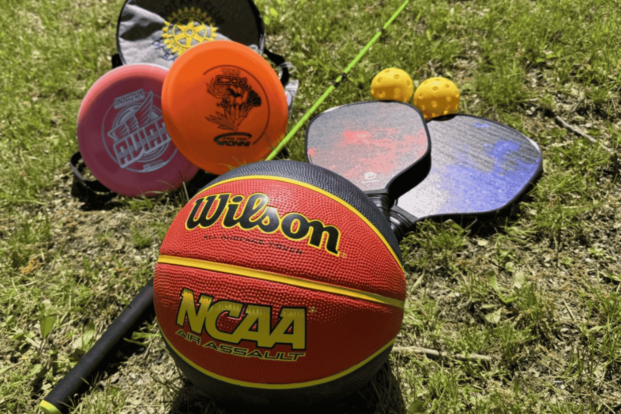 Basketball, fishing rod, frisbee discs, and pickleball rackets.